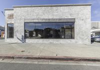 the storefront of an empty business on the corner of street corner has large windows