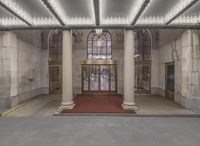 the entrance to this building features a red carpet and an arched window with lots of white light