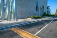 the sidewalk outside the entrance of a building and sidewalk with white lines leading to it