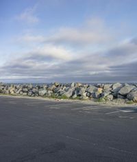 a parking lot filled with lots of rocks and rocks walling it around the sidewalk