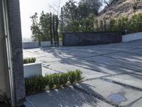 the exterior and landscape of a modern house in los angeles, california with stone and wood