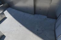 a picture of some trash cans and some tile flooring and walls outside of a building