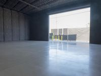 a gray concrete floor with a light from the inside is visible in this empty building