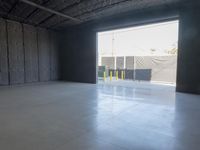 a gray concrete floor with a light from the inside is visible in this empty building