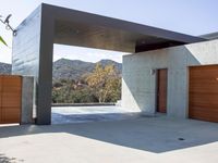 a gray concrete building with stairs and door at the top of the floor next to it is steps leading down to the doorway