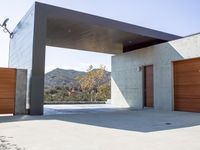 a gray concrete building with stairs and door at the top of the floor next to it is steps leading down to the doorway