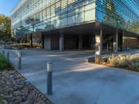 two grey blocks sitting next to a tall building on a sidewalk in front of grass