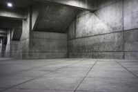 an empty dark concrete room with cement walls and flooring, and the lights on