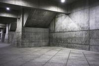 an empty dark concrete room with cement walls and flooring, and the lights on