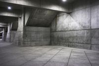an empty dark concrete room with cement walls and flooring, and the lights on
