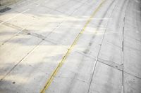 an overhead view looking down at a yellow line on a street in an empty city