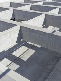 concrete blocks stacked in a complex with two open doors and a shadow cast from the floor