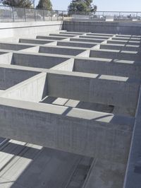 concrete blocks stacked in a complex with two open doors and a shadow cast from the floor