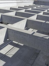 concrete blocks stacked in a complex with two open doors and a shadow cast from the floor