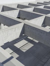 concrete blocks stacked in a complex with two open doors and a shadow cast from the floor