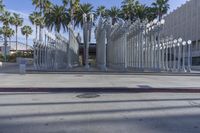 the outside view of the los county hall building, with several people walking on the sidewalk