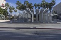 the outside view of the los county hall building, with several people walking on the sidewalk