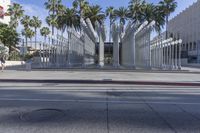 the outside view of the los county hall building, with several people walking on the sidewalk
