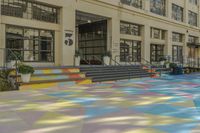 this is an image of a courtyard with multicolored tiles on the ground in front of a building