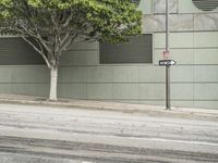 a person rides their bike on the street, near a building with shuttered windows