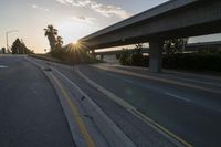 the sun is going down over a highway with palm trees in front of it and several ramps on either side