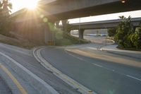the sun is going down over a highway with palm trees in front of it and several ramps on either side