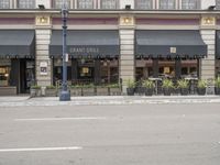 a building with awnings and tables in front of it on the street corner