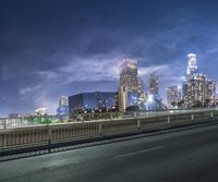 a picture of the city skyline on the horizon of the freeway with a lot of traffic and lights