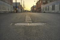 a street scene with an empty street and buildings in the back ground with power lines