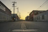 a street scene with an empty street and buildings in the back ground with power lines