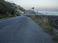 the empty street in front of the ocean is empty and full of cars going down it