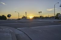 a bridge with a ramp and several street lights lit by the setting sun on the road