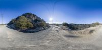 a dirt road with two large poles in the background with one on a bike going by