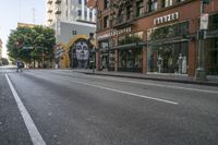 empty city street with a painting on the side of the building and parked cars behind it