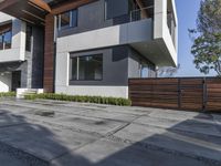 this beautiful home is surrounded by concrete and modern steel architecture and features large windows and an attached walkway