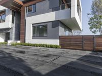 this beautiful home is surrounded by concrete and modern steel architecture and features large windows and an attached walkway