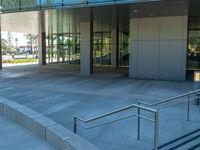 two grey blocks sitting next to a tall building on a sidewalk in front of grass