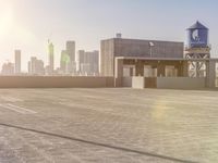 there is a car driving along a road with buildings in the background and water tower