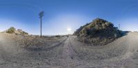 a dirt road is shown at the base of this photograph with two telephone towers in the distance