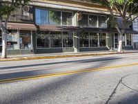 a motorcycle is parked on the side of a street in front of a storefront