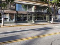 a motorcycle is parked on the side of a street in front of a storefront