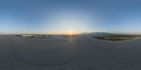 a fish eye view of a person riding a skate board on a ramp near the sunset