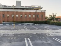 an empty parking lot with no one riding in it and building to the right of it