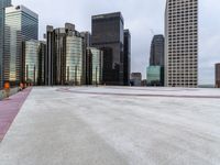 an empty parking lot surrounded by tall buildings with a circular design on it in the center