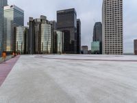 an empty parking lot surrounded by tall buildings with a circular design on it in the center