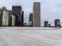 an empty parking lot surrounded by tall buildings with a circular design on it in the center