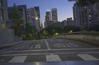 the empty road near tall buildings with signs on it and a stop sign with the word