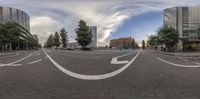 a panoramic shot looking at the corner of an empty street, with cars going on the right and buildings on the left