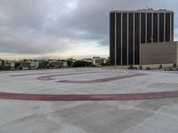 the letter u is painted in red on the asphalt outside of a city building with other buildings behind it