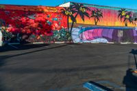 the painted wall in this parking lot is full of different colors and shapes on it